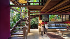 A wooden staircase leading to a balcony with a view of lush greenery. - Pousada Hibisco (Porto Seguro)