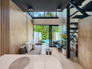 Un intérieur moderne avec un canapé, une table ronde et un escalier.