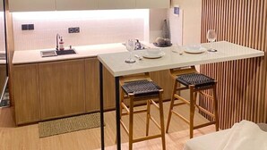 A modern kitchen with a central island, wooden cabinets, and a ceiling fan. - Luxury Private Pool Loft Canggu (Canggu)