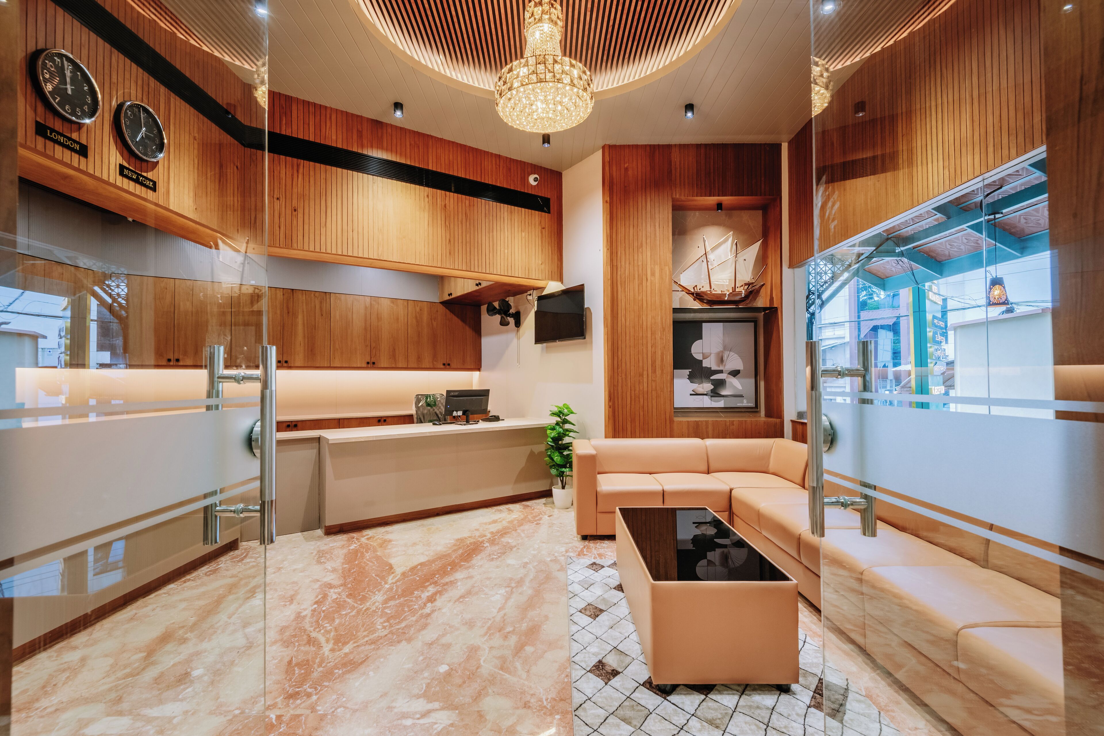 A modern kitchen with wooden cabinets, a marble countertop, and a built-in seating area with a coffee table.