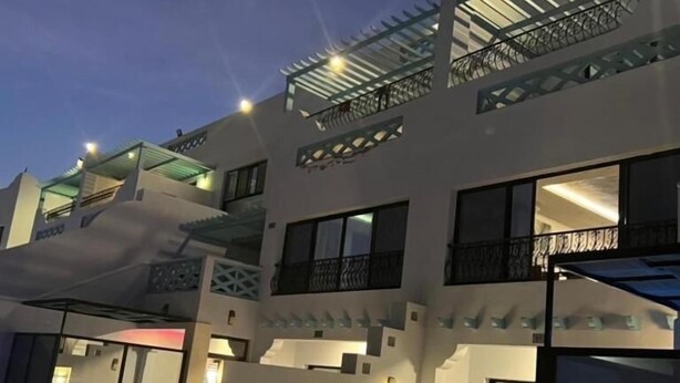 A modern multi-story building with balconies, large windows, and outdoor seating areas. - La Fontain lagoon resort  (Jeddah)