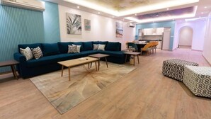 A modern living room with a sectional sofa, a coffee table, and a patterned rug. - La Fontain lagoon resort  (Jeddah)