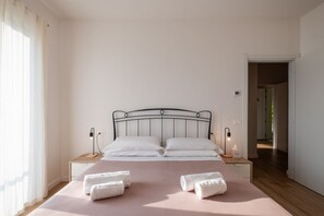 Ein Schlafzimmer mit einem Bett, zwei Nachttischen, einem Fenster mit Vorhängen.