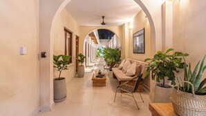 Un pasillo con sofá, mesa de centro y plantas en macetas.
