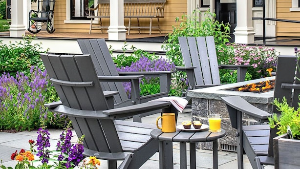 Une maison avec un porche, un espace salon extérieur et un jardin.