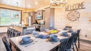 Una cocina moderna con paredes de madera, un letrero de bienvenida y un reloj.