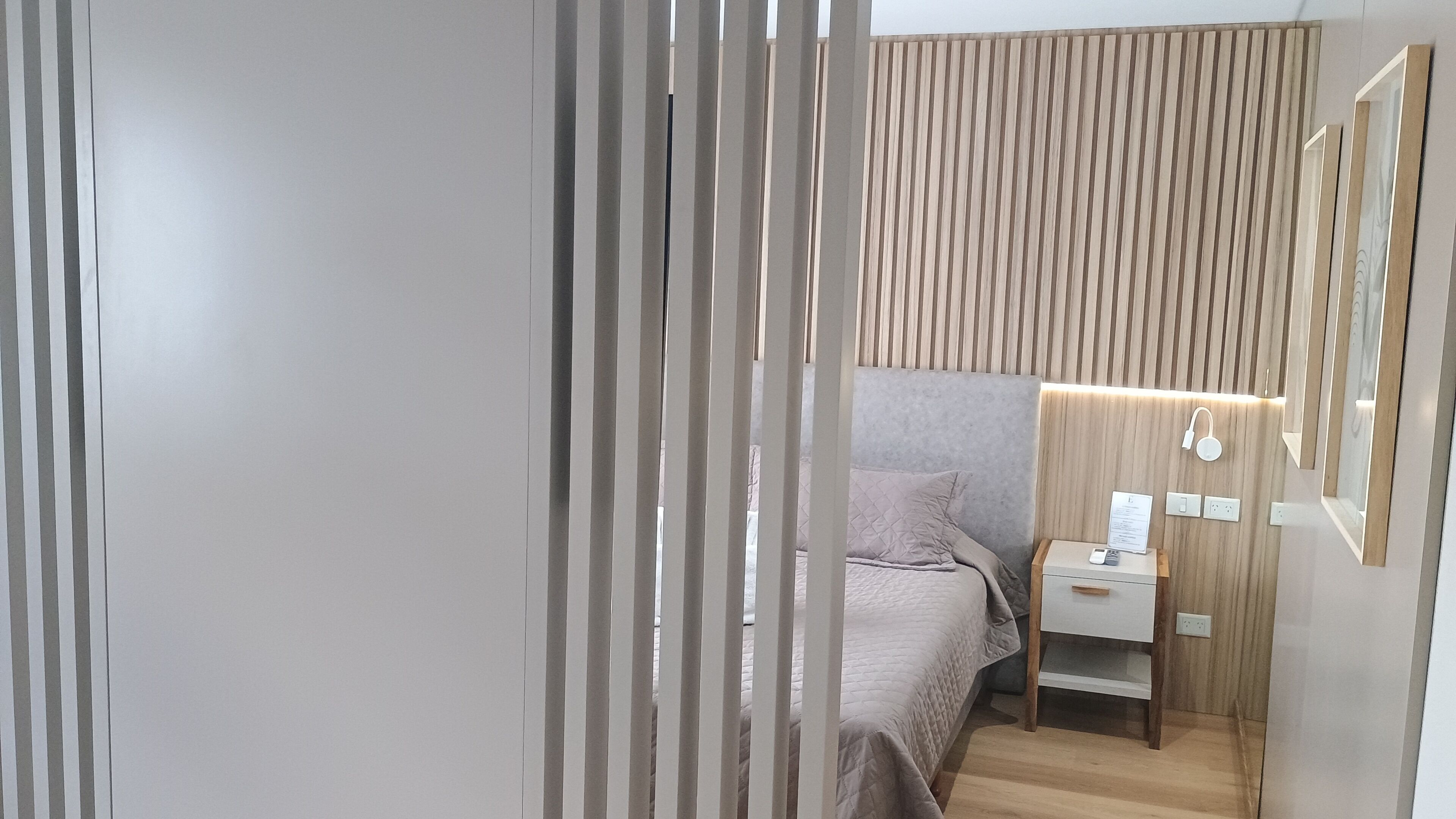 Un dormitorio moderno con cama, mesita de noche y lámpara.