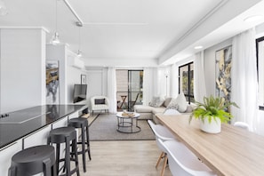 A modern living space with a kitchen, dining area, and seating area. - Sausalito 201 (Cape Town)