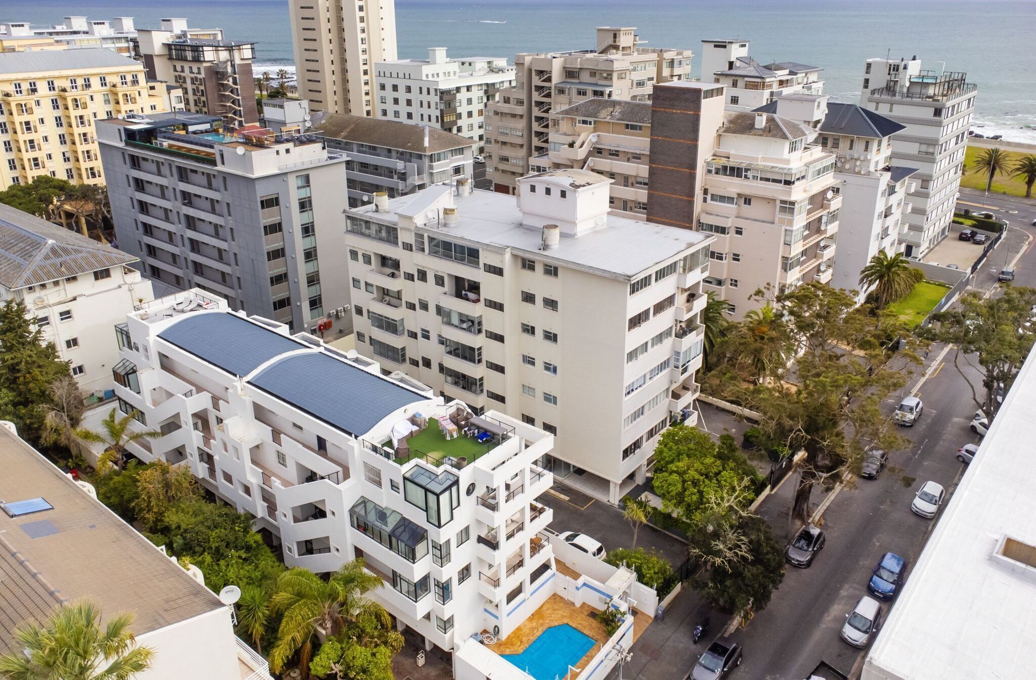 Un immeuble de grande hauteur doté de nombreux balcons, d’une piscine sur le toit et offrant une vue sur l’océan.