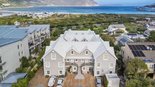 A residential building with a central courtyard, surrounded by lush greenery and a view of the ocean. - Summerville 20 (Cape Town)