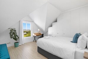 A modern bedroom with a large bed, a desk, and a potted plant. - Summerville Beach Loft (Cape Town)
