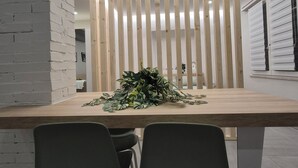 A modern dining area with a wooden table, two chairs, and a decorative plant centerpiece. - Love Pisa | Elegante Loft nel cuore di Pisa (Pisa)