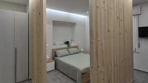 A modern bedroom with a bed, nightstands, and a wardrobe. - Love Pisa | Elegante Loft nel cuore di Pisa (Pisa)