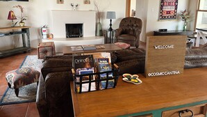 A cozy living room with a fireplace, leather armchair, and a coffee table with magazines. - Cosmic Cantina - Easy Stays and Great Location! (El Prado)