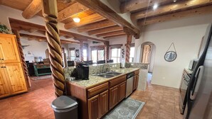 A kitchen with wooden beams, granite countertops, and a central island. - Cosmic Cantina - Easy Stays and Great Location! (El Prado)