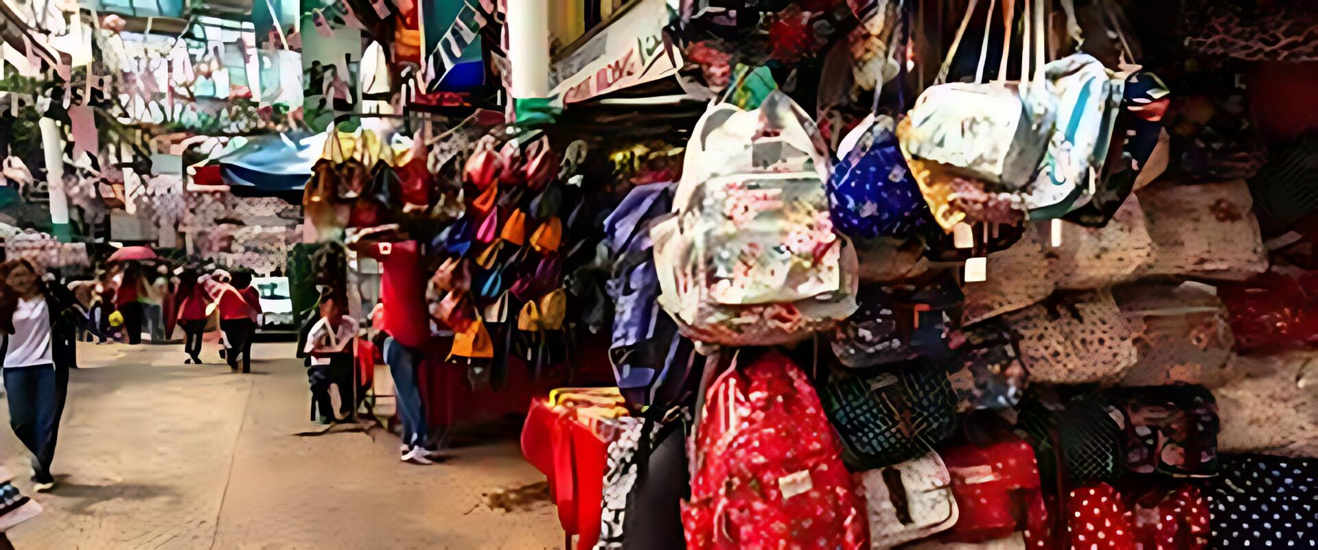 Ein Markt mit verschiedenen Ständen, an denen Taschen und Textilien angeboten werden.
