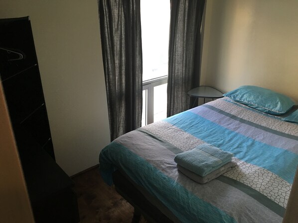 A bedroom with a bed, a small table, a wardrobe, and a window with curtains. - 3D - Lovely (Brooklyn)