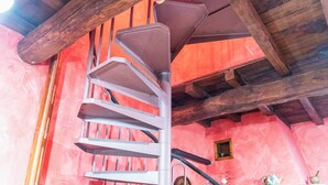 Eine Wendeltreppe mit Holzboden und rosafarbenen Wänden.