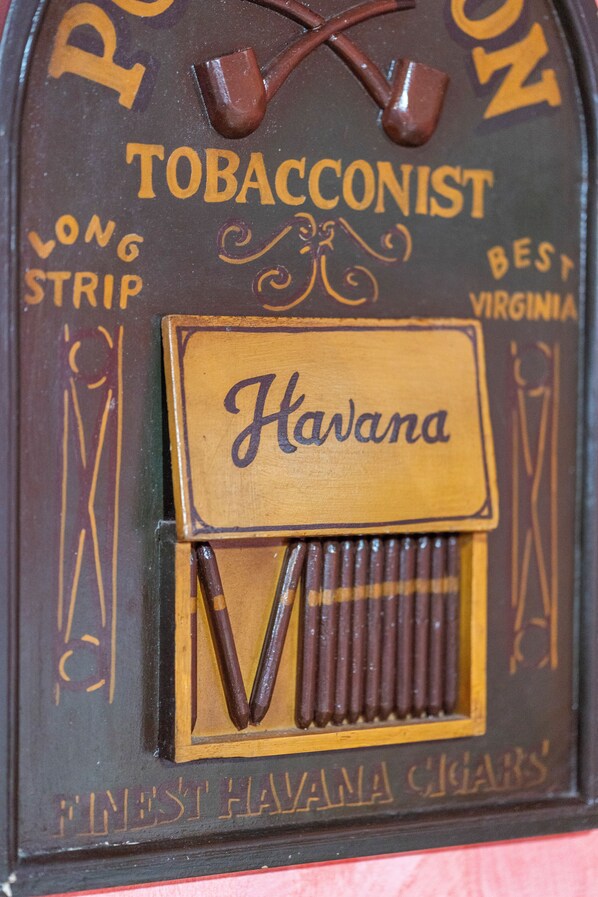 A cigar box with "TOBACCONIST" and "Havana" labels, and a depiction of a person smoking a cigar.