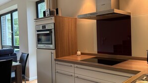 Una cocina moderna con horno integrado, extractor Bosch y encimera de madera.