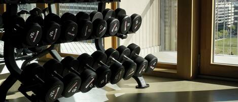 A gym with a rack of dumbbells and a sign reading "Rooftop Hina".