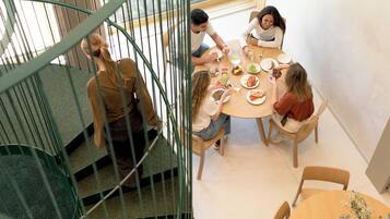 A dining area with a spiral staircase, a round table, and chairs.