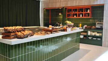 Una barra de desayuno buffet con diferentes alimentos y un tostador.