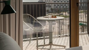 A balcony with a table and chairs, a view of buildings, and a curtain. - KORA KILIKI (Pamplona)