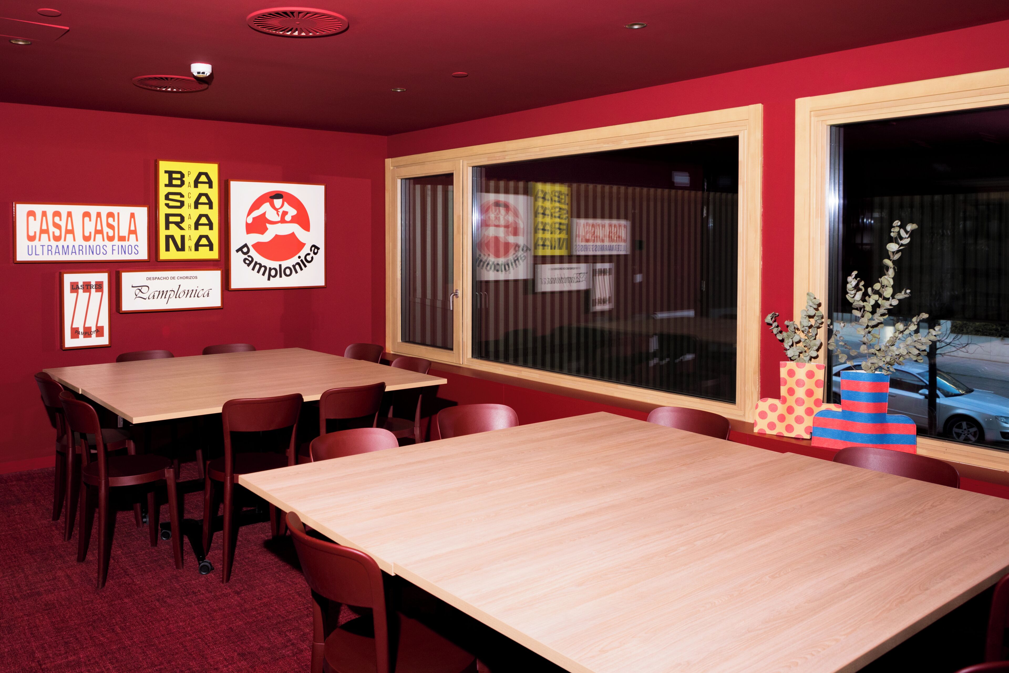 A conference room with a large table, chairs, and a window with blinds.