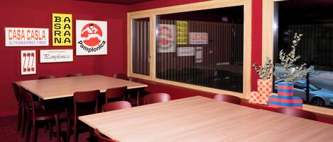 A conference room with a large table, chairs, and a window with blinds.