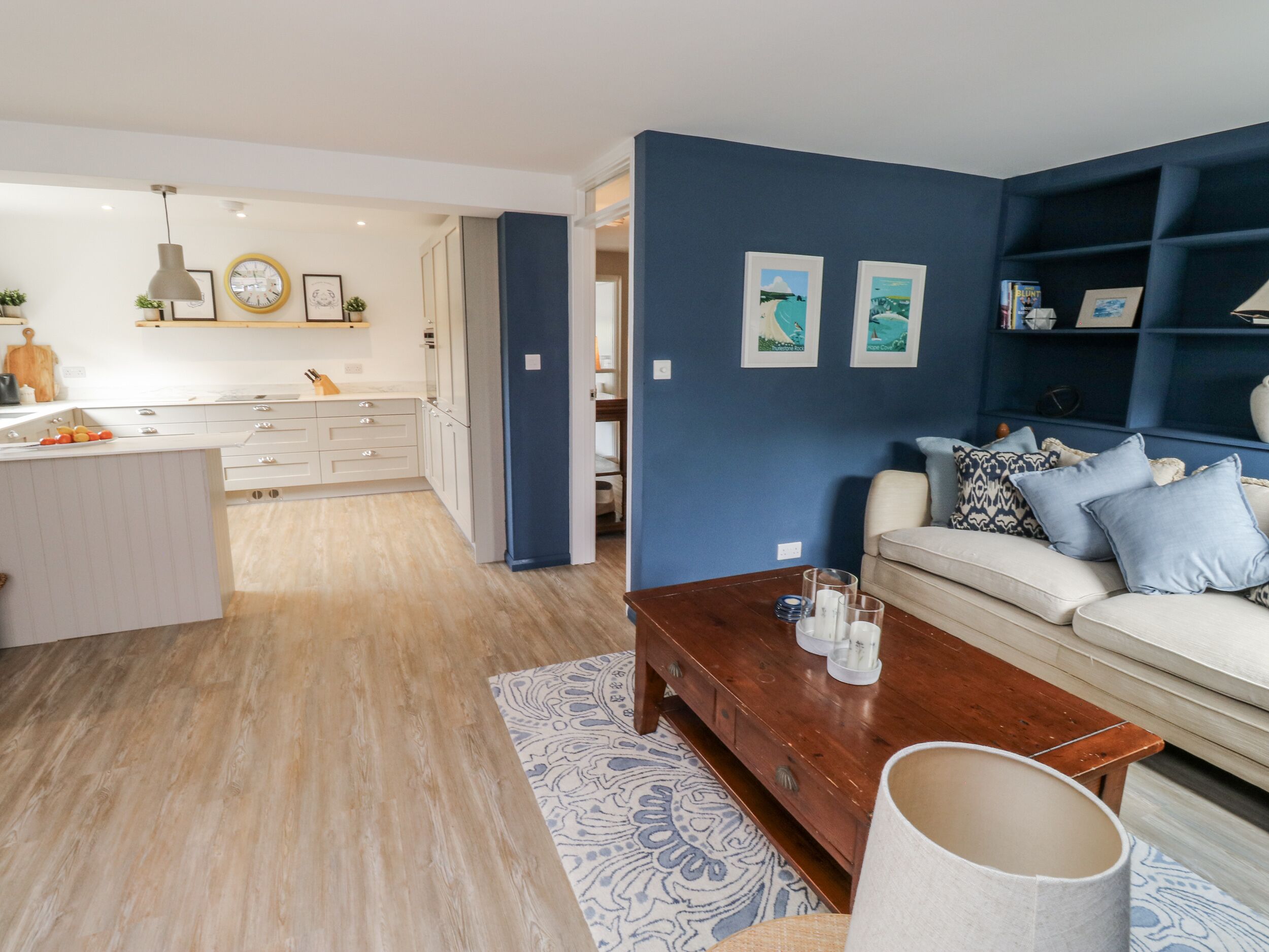 A modern living room with a sofa, coffee table, and a blue accent wall.