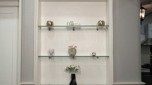 A white wall with a built-in shelf unit displaying decorative items. - Eden Garden By Jolly Homes (Madurai)