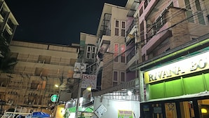 A street view at night with buildings, a sign for 'Rivana Bo' restaurant, and a 'Taxi Service' sign.