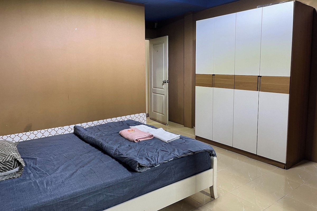 A bedroom with a bed, a wardrobe, and a door.
