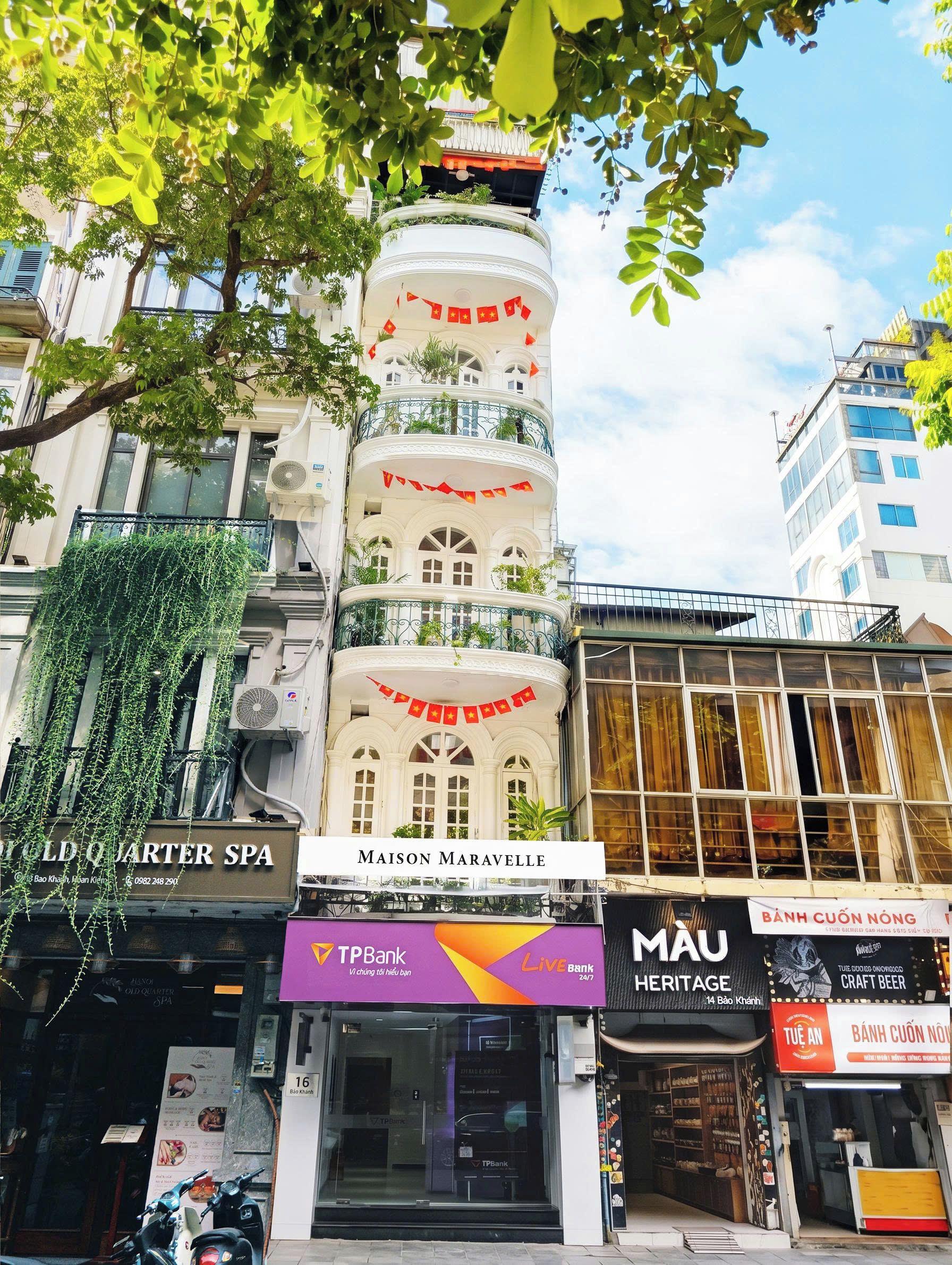 A multi-story building with a prominent sign for 'MAISON MARAVELLE' at the ground level.