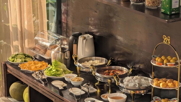 Un buffet proposant une variété de plats, notamment des salades, des viandes et des produits de boulangerie.