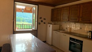 Una cucina con pensili e basi in legno, un frigorifero, un lavello e un forno.
