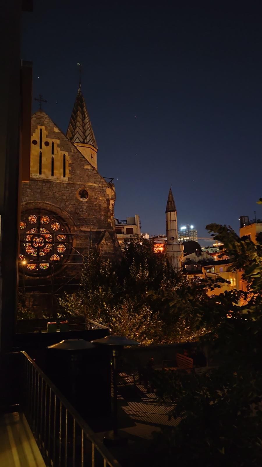 A historic building with a prominent tower and a large circular stained glass window.