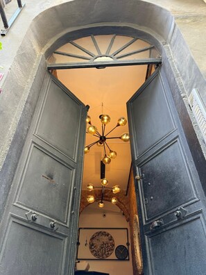 A narrow hallway with a decorative ceiling light fixture and a wall-mounted clock. - Stories Of Galata (İstanbul)