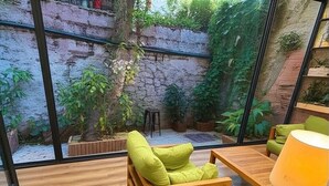 A modern room with a wooden floor, a green cushioned chair, a wooden table, and a lamp. - Stories Of Galata (İstanbul)
