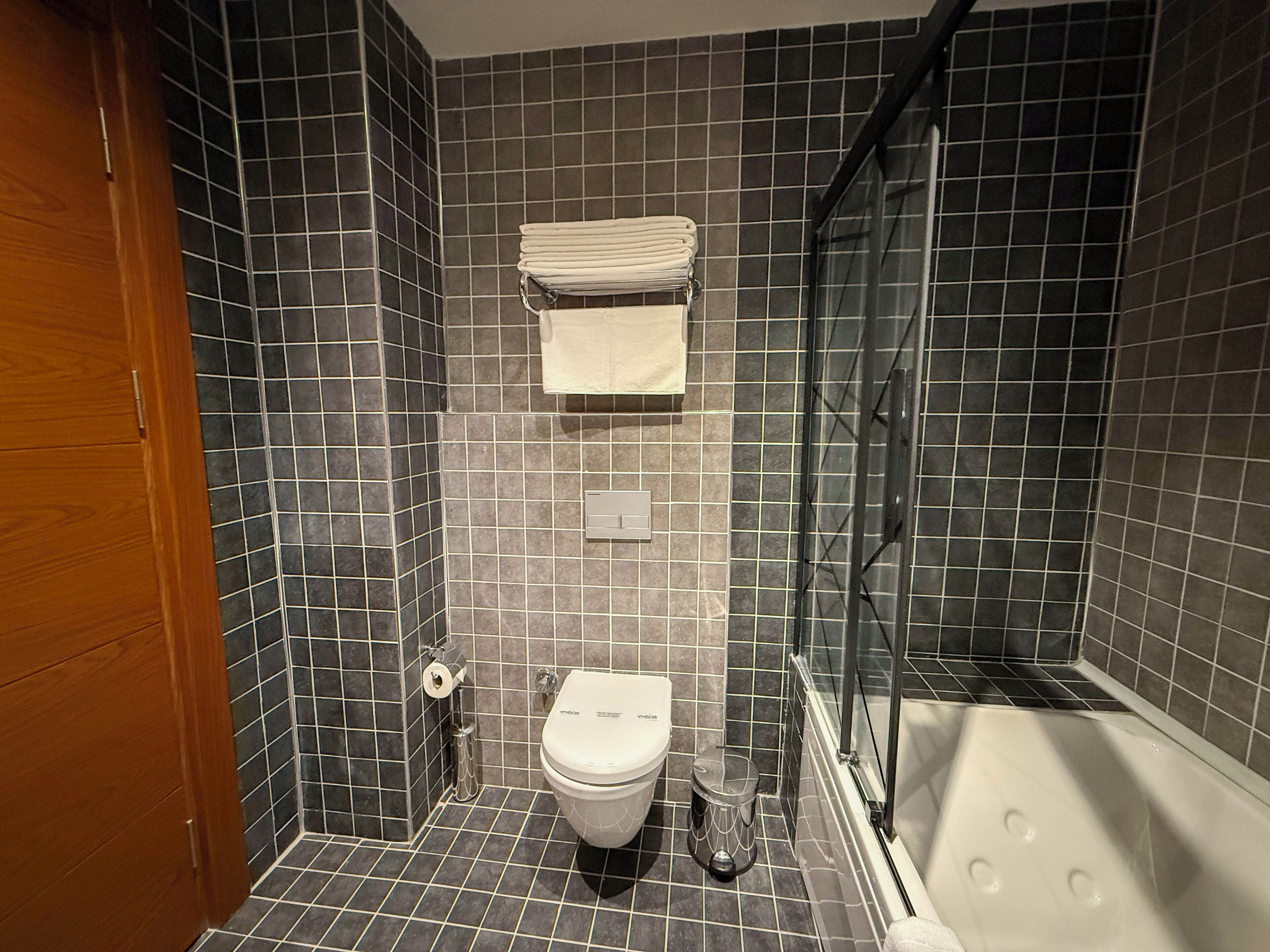 Un baño con inodoro, lavabo, cabina de ducha de vidrio y bañera.