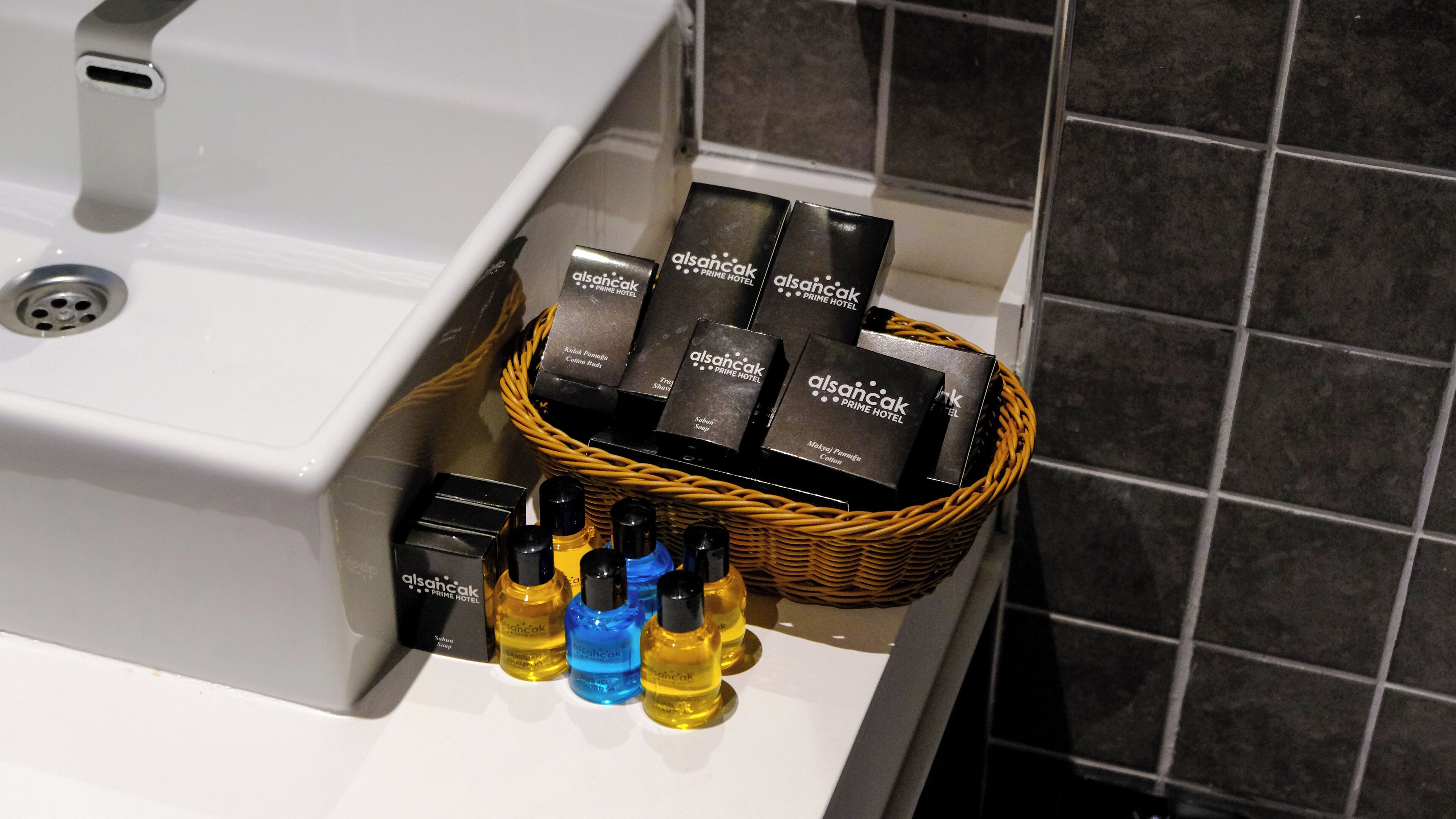 Et badeværelsesstel med en kurv til toiletartikler og en sæbedispenser.