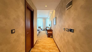 A hotel hallway with a carpeted floor, a wooden door, and a reception desk with a computer and a phone. - ALSANCAK PRIME HOTEL KONYA  (Konya)