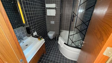 A bathroom with a bathtub, toilet, and shower.