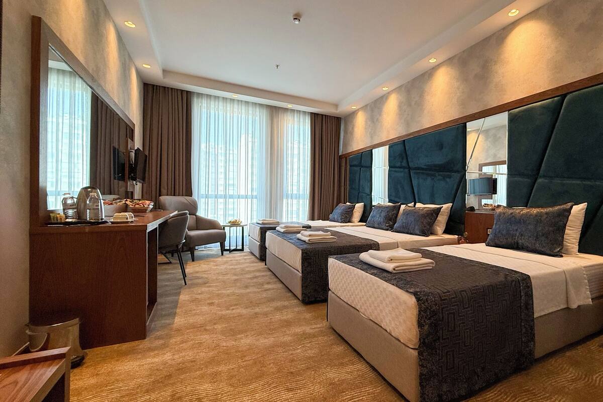 Deluxe Quadruple Room, City View | In-room safe, desk, laptop workspace, blackout drapes