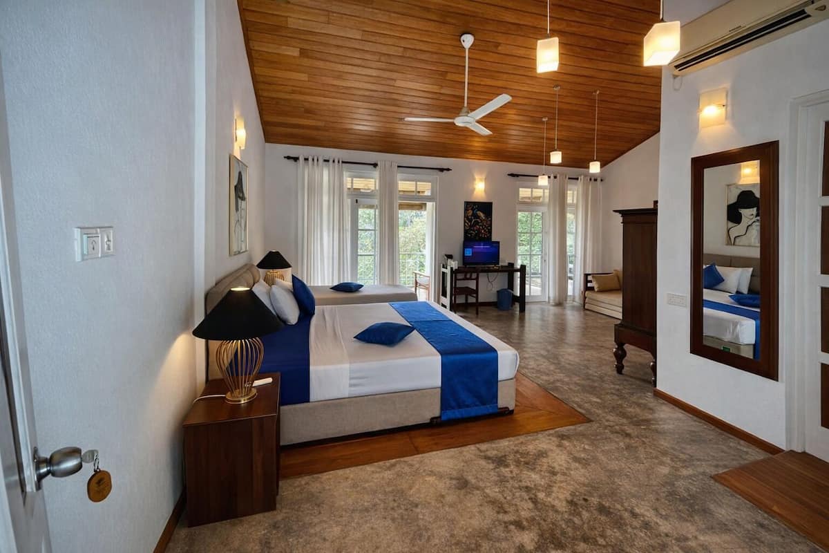 A spacious bedroom with a large bed, a desk, and a television.