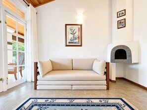 A living room with a sofa, a fireplace, and a framed picture on the wall. - Forest Edge Hotel (Ginigathhena)
