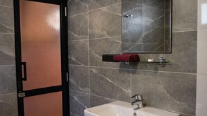 A bathroom with a white sink, a mirror, and a towel rack. - Forest Edge Hotel (Ginigathhena)