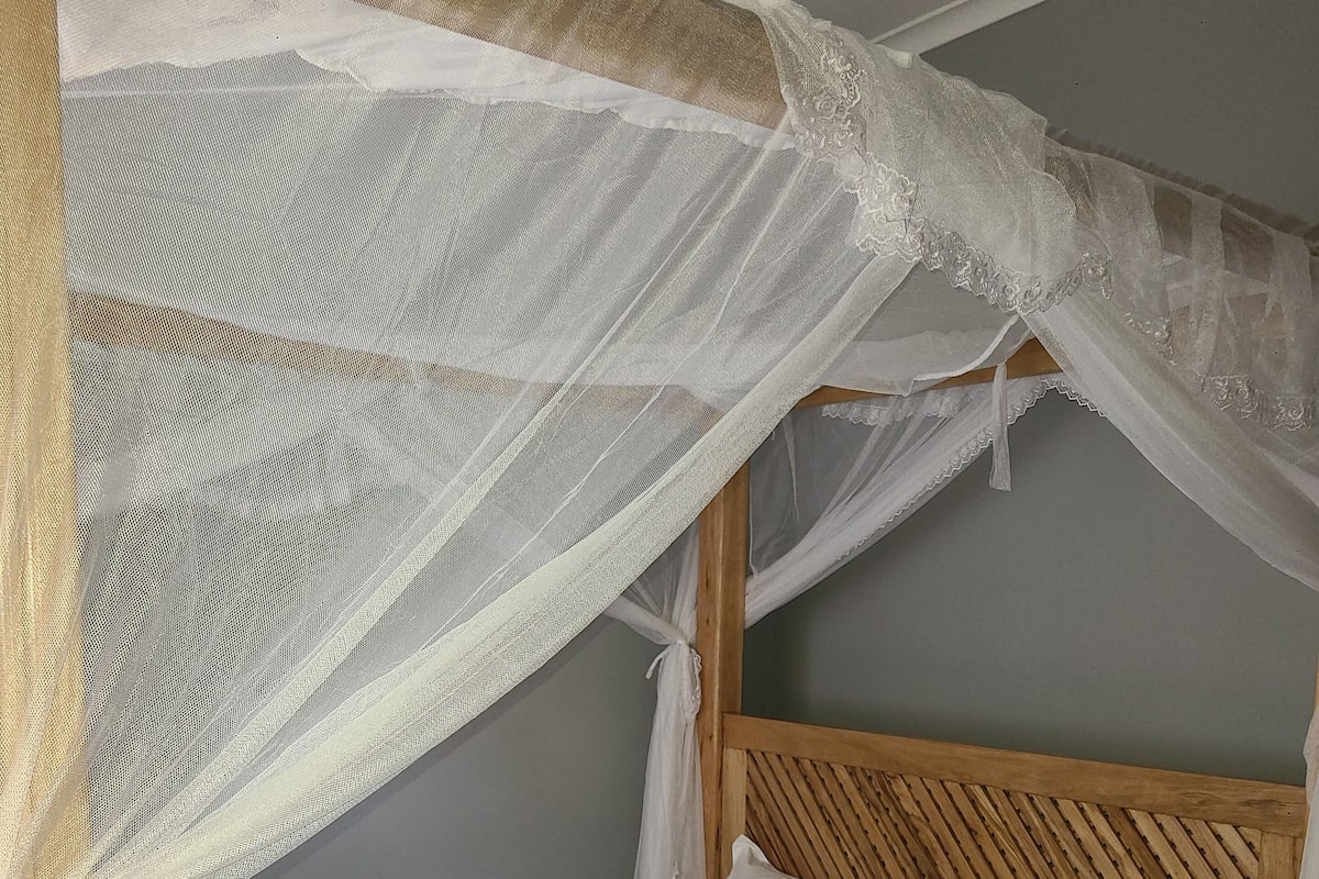 A bed with a wooden headboard and a canopy.