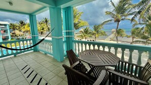 A turquoise balcony with a view of the beach and palm trees. - Sunset Beach Resort (San Pedro)